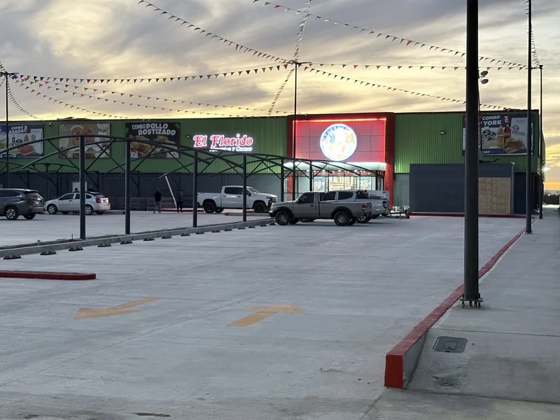 Fachada comercial de El Florido con integración de anuncios luminosos.