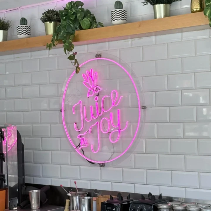 Letrero circular rosa Juice Joy en interior